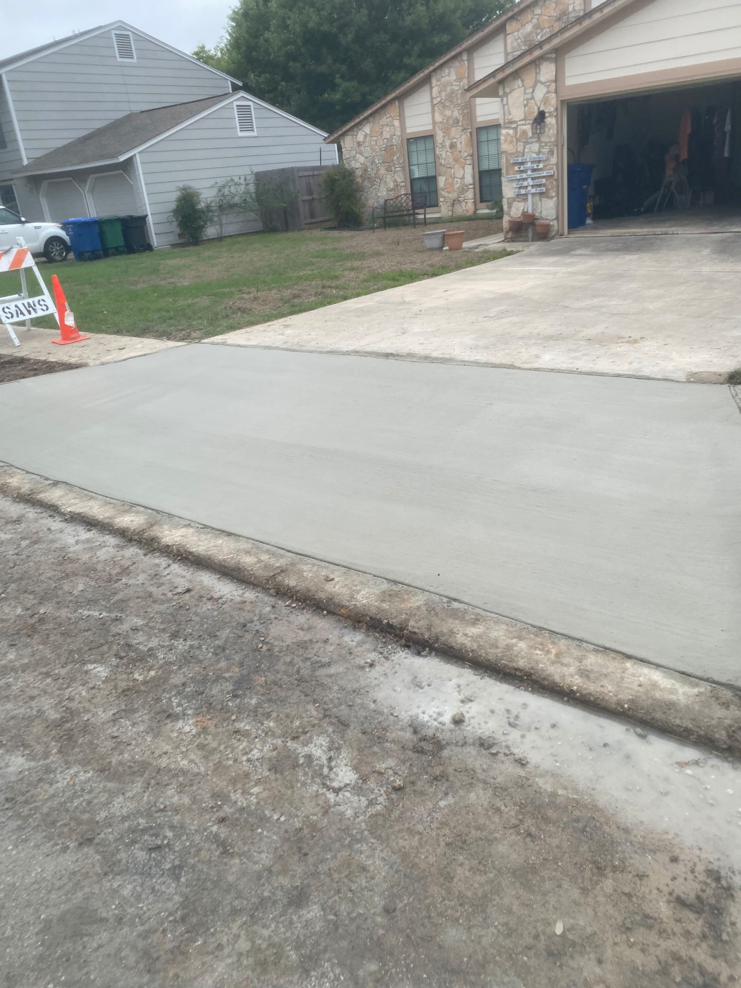 New concrete driveway apron poured between the street and an existing driveway