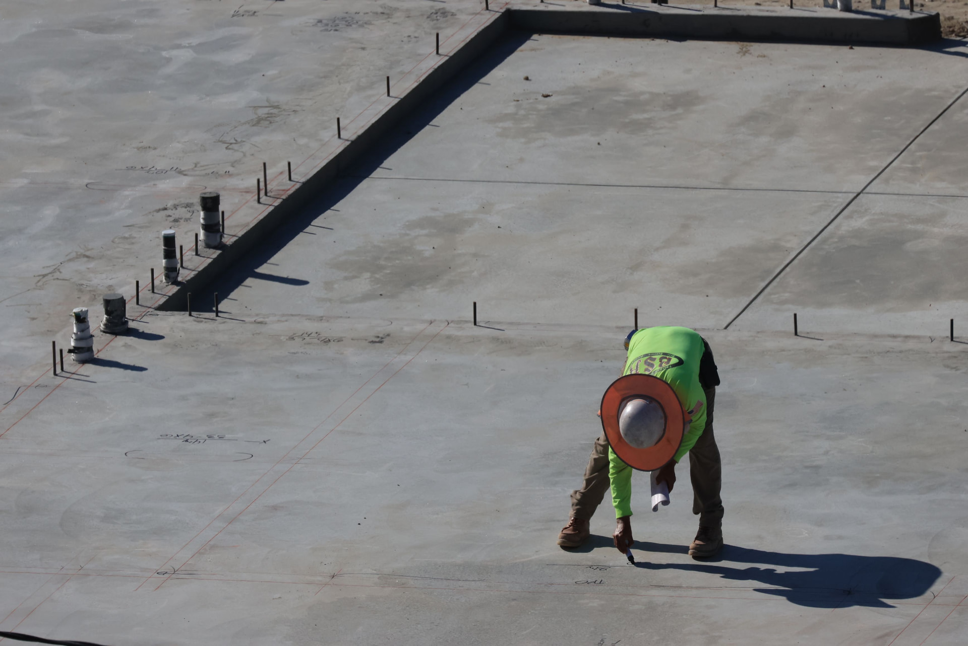 Concrete finisher marking control joints on a freshly poured slab